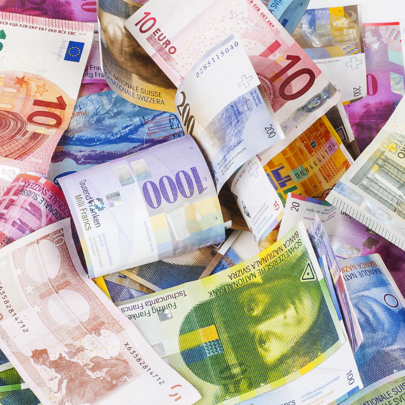 Verschiedene Geldscheine aus Europa und der Schweiz liegen übereinander