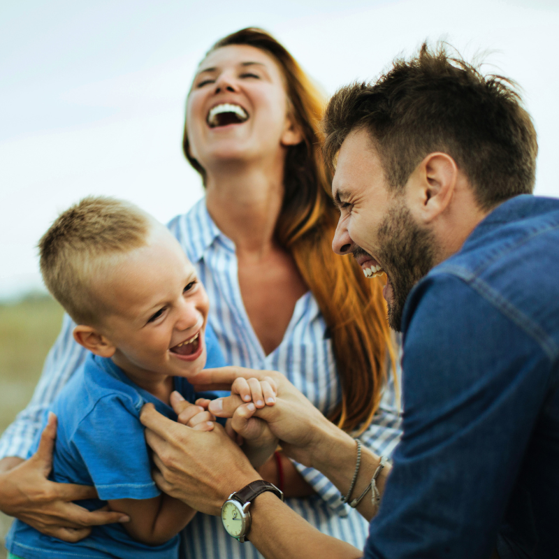 Familie spielt lachend miteinander und wirkt glücklich und verbunden